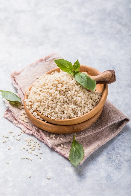 Riz brun non poli dans un bol en bois. Fond de riz à grain long.