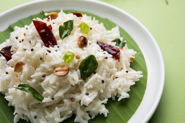 Riz caillé ou Dahi Bhat OU Chawal avec feuille de curry, arachides et piment - Servi dans un bol sur fond de mauvaise humeur. Mise au point sélective