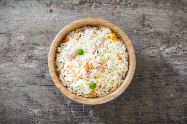 Riz chinois frit aux légumes sur la vue de dessus de table en bois