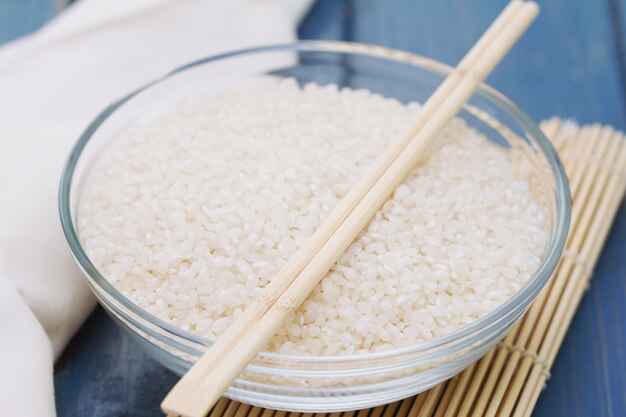 Riz cru dans un bol sur une table en bois