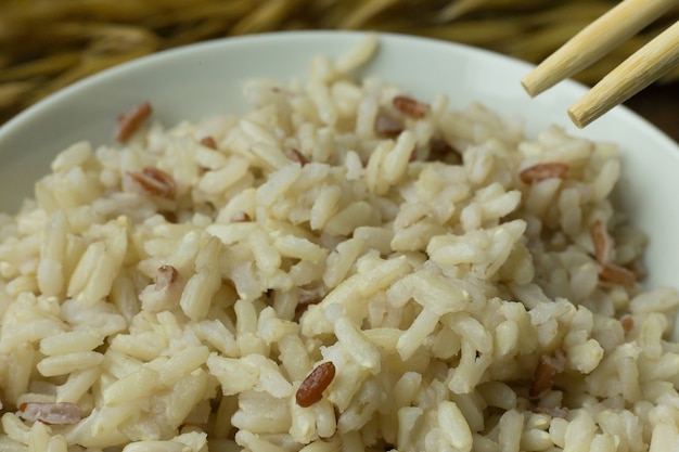 Riz cuit au jasmin, riz brun dans un bol sur une table en bois.