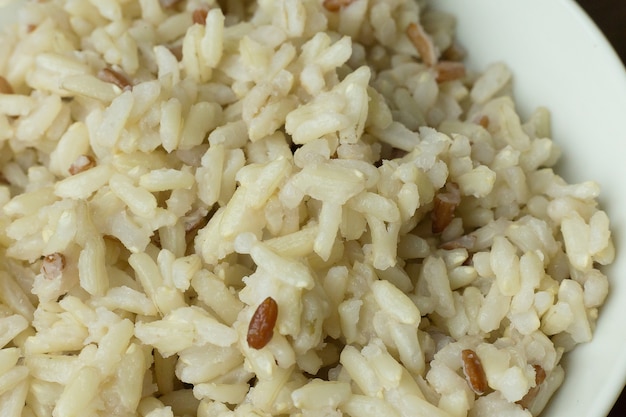 Riz cuit au jasmin, riz brun dans un bol sur une table en bois.