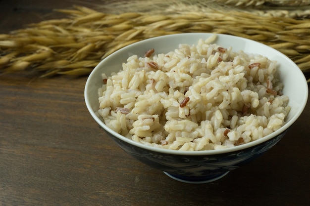 Riz cuit au jasmin, riz brun dans un bol sur une table en bois.