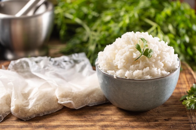 Riz cuit dans un bol avec du riz cru dans des sacs en plastique