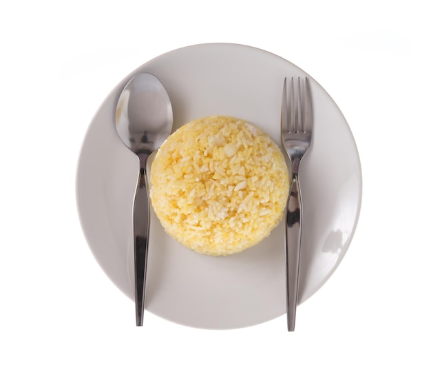riz dans une assiette / une portion de riz jaune cuit dans un plat en céramique blanche