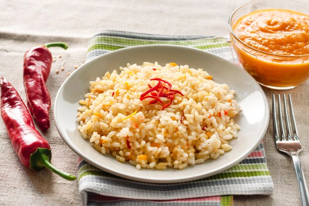 Riz épicé aux carottes et piments sur une plaque grise