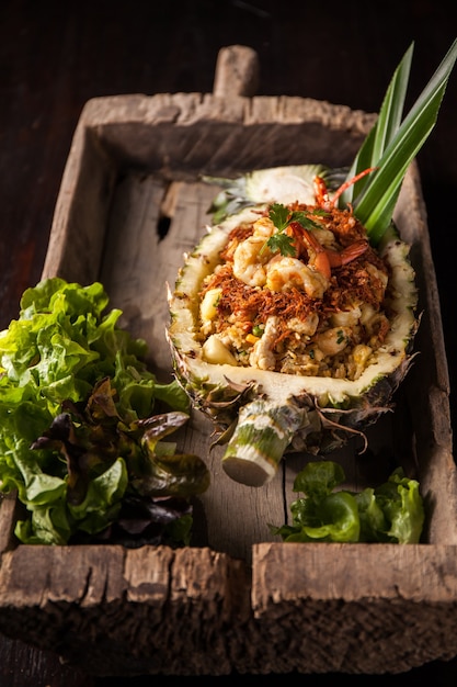 Riz frit à l'ananas sur plaque en bois