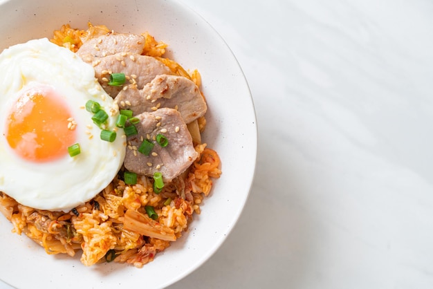 Riz frit au kimchi avec oeuf au plat et porc - style de cuisine coréenne