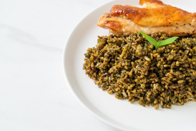 Riz frit au pesto avec poulet grillé sur plaque blanche