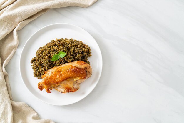 Riz frit au pesto avec poulet grillé sur plaque blanche