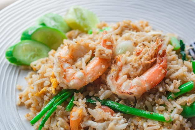 Riz frit aux crevettes sur le plat blanc.