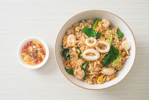 Riz frit avec calmar ou poulpe dans un bol - riz sauté avec calmar, œuf et chou frisé