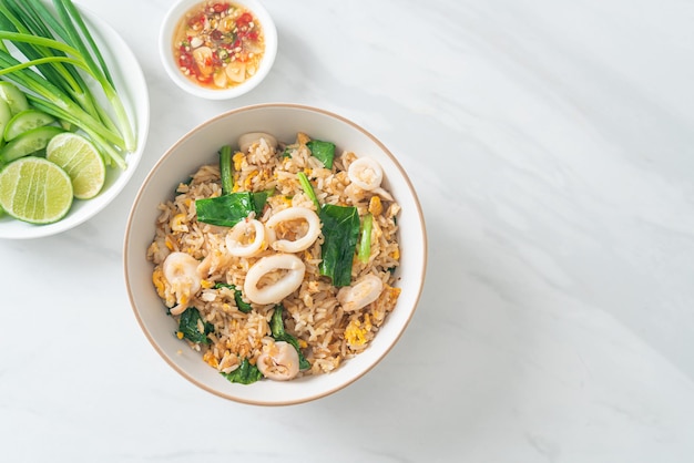 Riz frit avec calmar ou poulpe dans un bol - riz sauté avec calmar, œuf et chou frisé