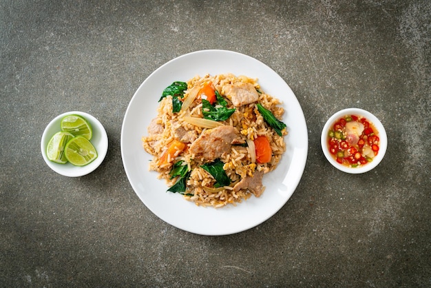 Riz frit fait maison avec du porc sur une plaque blanche