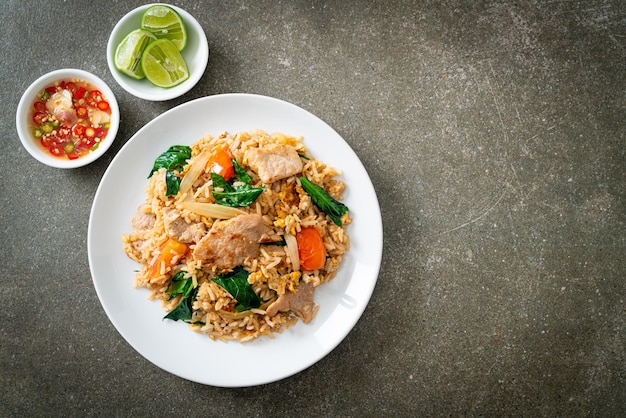 Riz frit fait maison avec du porc sur une plaque blanche