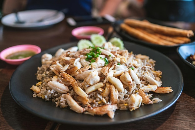 Riz frit avec des morceaux de crabe frais pleins frits avec un style chinois à haute température pour une odeur fumée Servi avec des tranches d'échalote et de concombre Cuisine de style chinois et thaïlandais à Bangkok