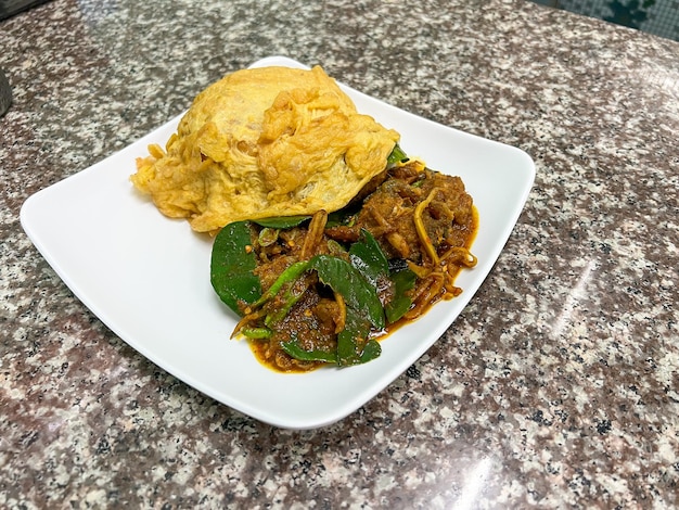 Riz garni de poisson-chat sauté épicé au curry, un aliment facile à trouver en Thaïlande