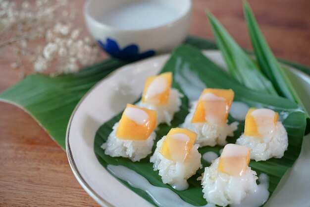 Riz gluant à la mangue mûre au lait de coco desserts thaïlandais authentiques sur une table en bois