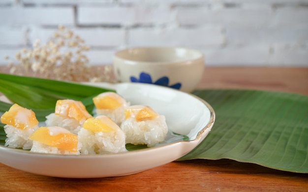 Riz gluant à la mangue mûre au lait de coco desserts thaïlandais authentiques sur une table en bois