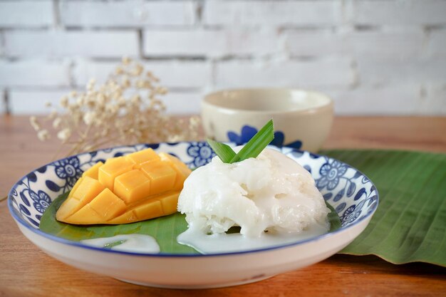 Riz gluant à la mangue mûre au lait de coco desserts thaïlandais authentiques sur une table en bois