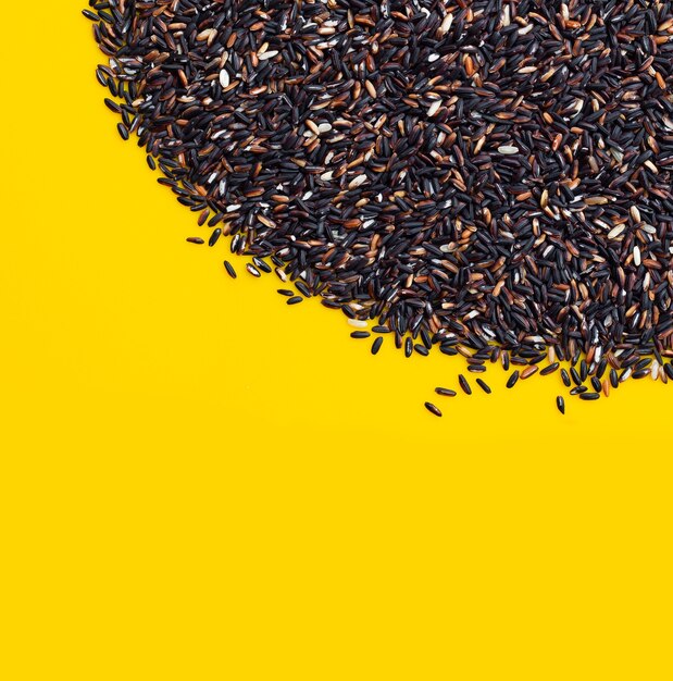 Riz gluant noir cru sur fond jaune.