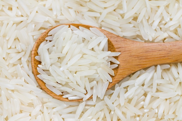 Riz à grain long non cuit dans une cuillère en bois