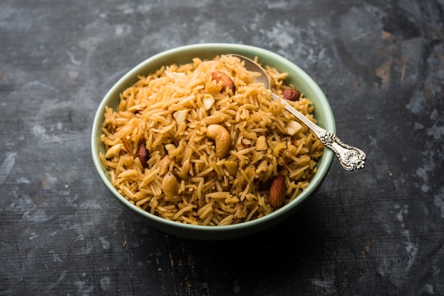 Riz Jaggery traditionnel ou Gur Wale Chawal en hindi, servi dans un bol avec une cuillère. mise au point sélective