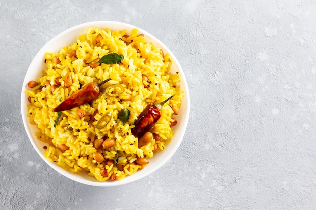 Riz jaune, riz au curcuma avec citron, gingembre et fenugrec dans un bol blanc, cuisine indienne