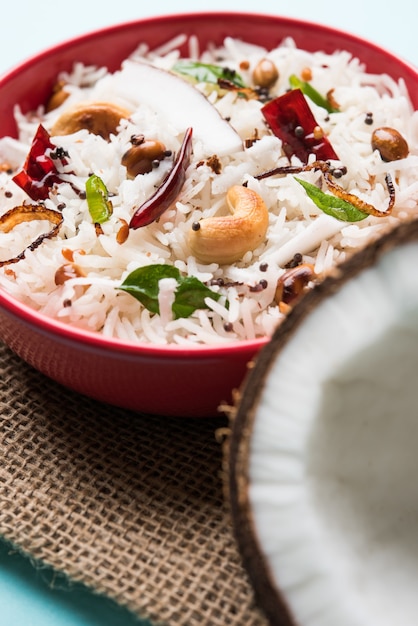 Riz à la noix de coco - recette de l'Inde du Sud utilisant des restes de riz basmati cuit, servi dans un bol rouge sur fond de mauvaise humeur, mise au point sélective