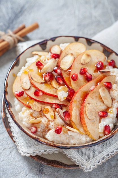 Riz à la noix de coco avec tranches de grenade, poire, cannelle et amande