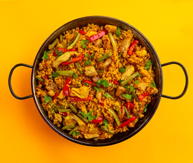 Riz paella espagnol au poulet sur fond jaune