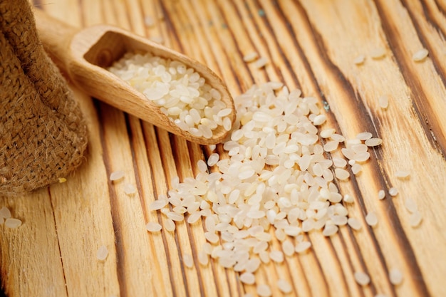 Riz rond poli dans des bols et des sacs sur un fond en bois Photo de haute qualité