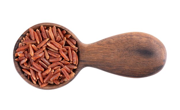 Riz rouge isolé dans une cuillère en bois sur fond blanc Riz brun cru à grains entiers Vue de dessus