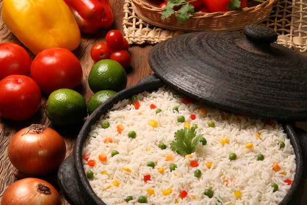 Riz sain appétissant avec des légumes dans une assiette blanche sur une table en bois. couleur de riz