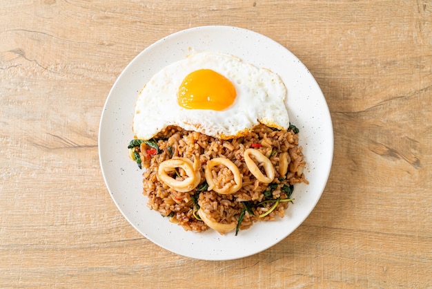 Riz sauté aux calamars et œuf au plat garni de basilic à la thaïlandaise