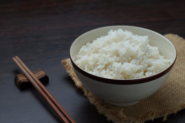 Riz thaïlandais avec des baguettes sur fond de bois