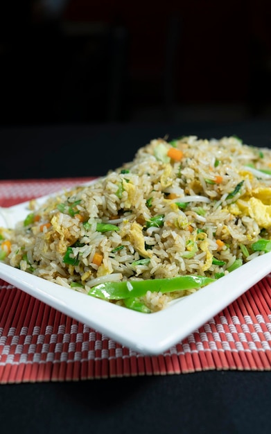 riz végétarien chaufa, gros plan, servi dans une assiette carrée.