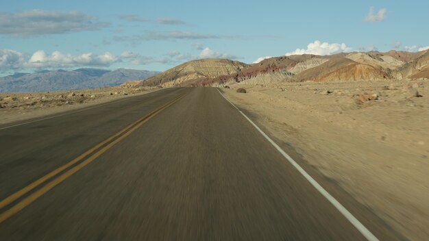 Road trip à Death Valley, Artists Palette drive, California USA. Auto-stop voyageant en Amérique. Autoroute, montagnes nues colorées et nature sauvage au climat aride. Vue depuis la voiture. Voyage au Nevada.