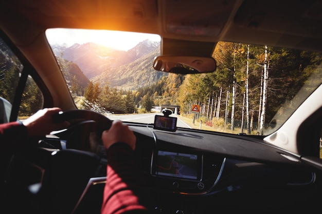 Roadtrip - les mains de l'homme sur le volant et les montagnes. Alpes, Autriche