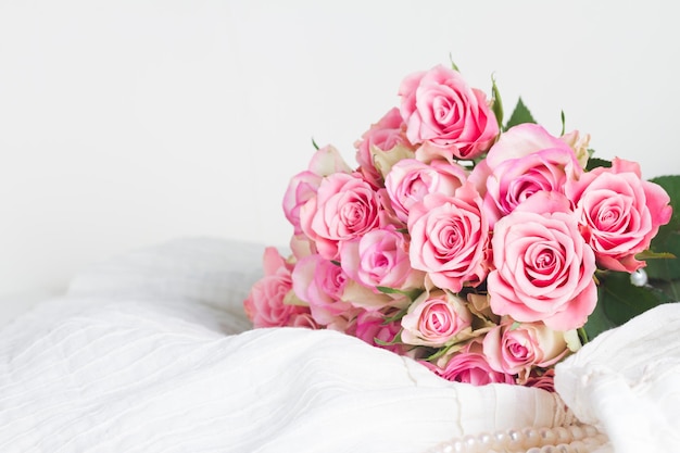 Robe en dentelle femme avec bouquet de fleurs de rose freash sur chaise