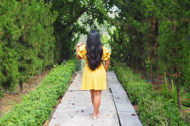 Robe jaune femme voyageur avec fond de forêt