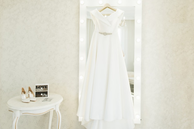 Robe de mariée accrochée au miroir