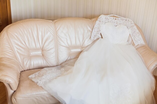 Photo la robe de mariée sur le canapé.