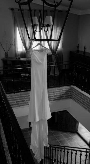 Une robe de mariée est accrochée à un cintre sur un balcon.