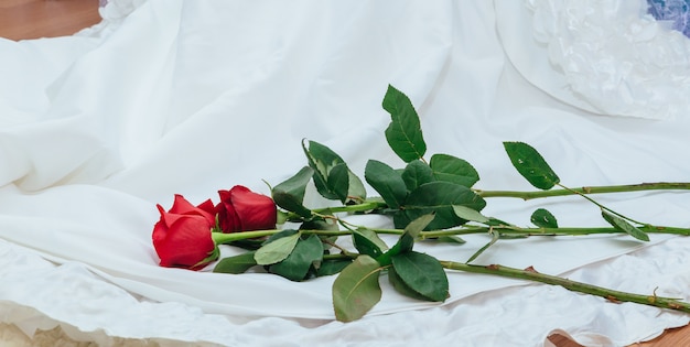 La robe de mariée parfaite avec une jupe ample dans la chambre robe de mariée tenir rose rouge