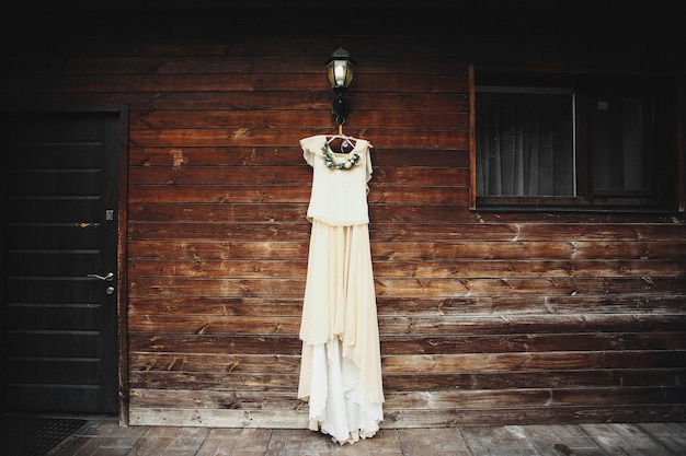 Robe de mariée suspendue sur un mur en bois