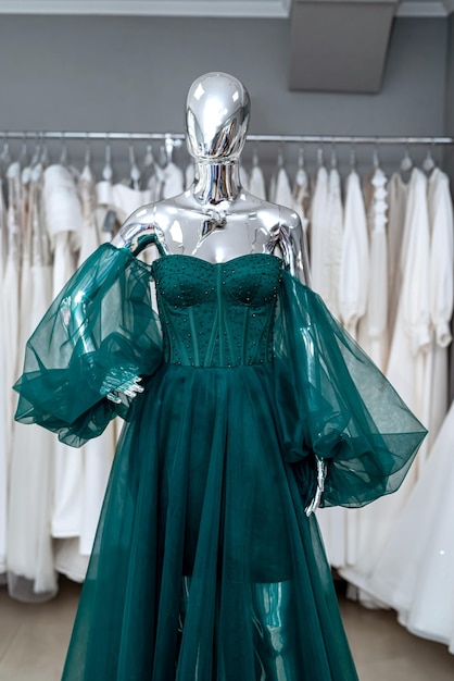 Robes de soirée vertes pour femmes sur mannequin dans le concept de mode de magasin de vêtements moderne