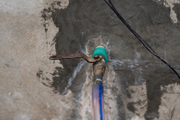 Robinet d'eau en métal grunge manipulé le foie de commande de vanne d'eau en fer rouillé