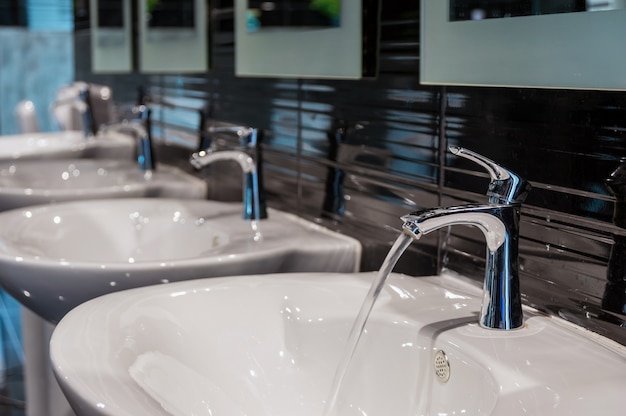 Robinet de la rangée de Chrome avec lavabo dans les toilettes modernes