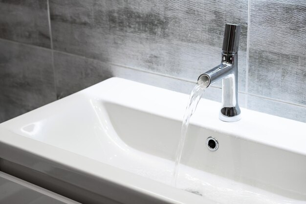 Robinet de salle de bain moderne Eau qui coule de l'espace de copie du robinet d'eau